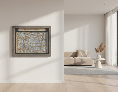 Wooden framed map of Los Angeles, California on a white surface with a beige background