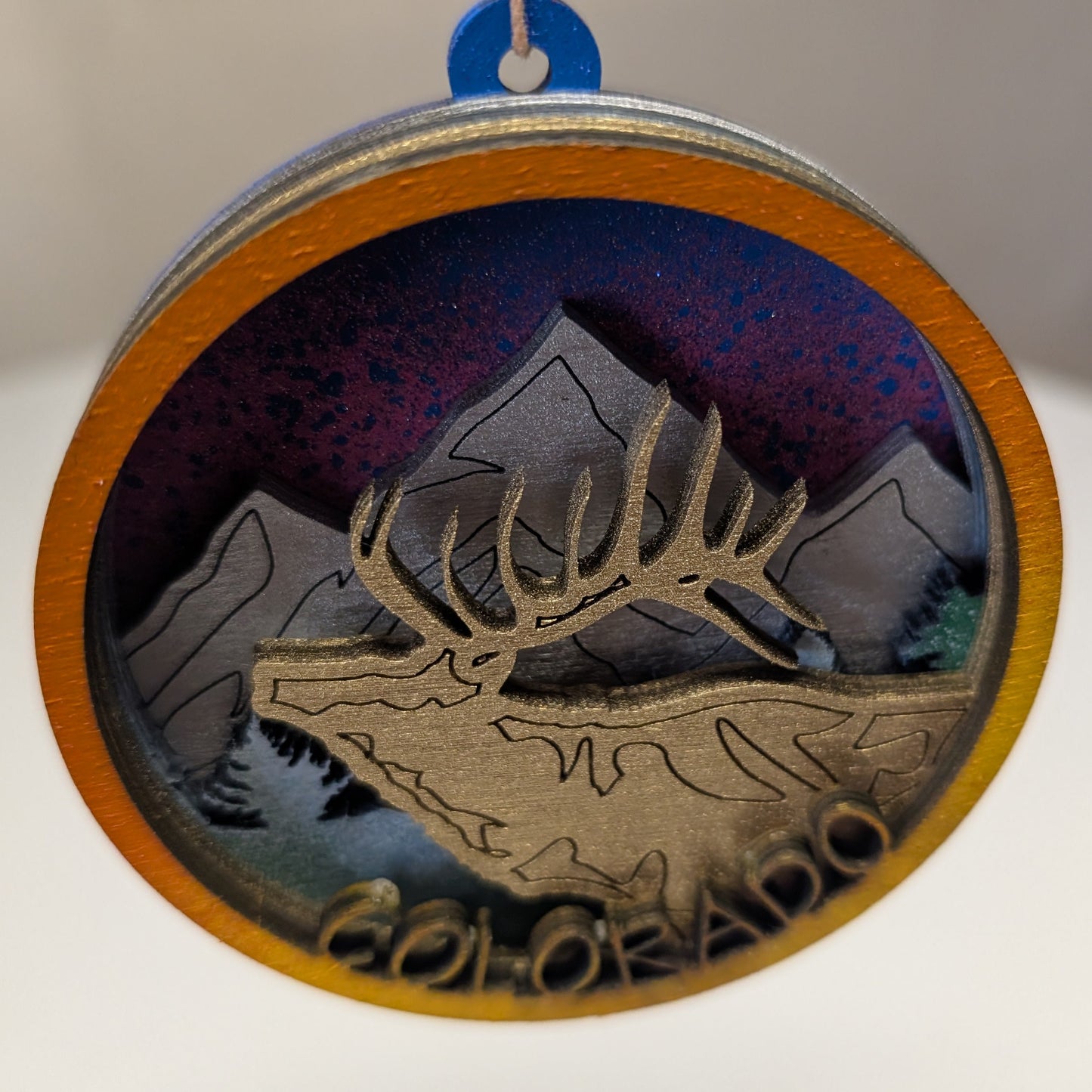 Decorative ornament with an elk and mountain design on a starry night background